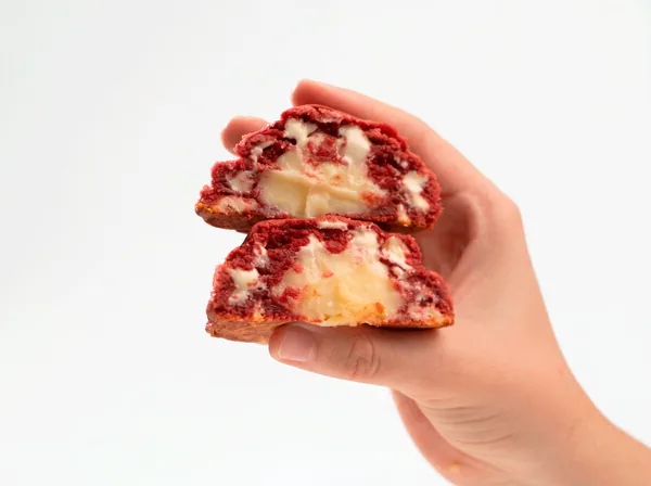 Cookie Monlebu partido ao meio: massa red velvet com recheio branco de brigadeiro de cream cheese