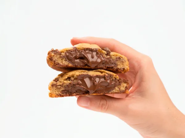 Cookie de Nutella partido ao meio, com recheio de avelã escorrendo