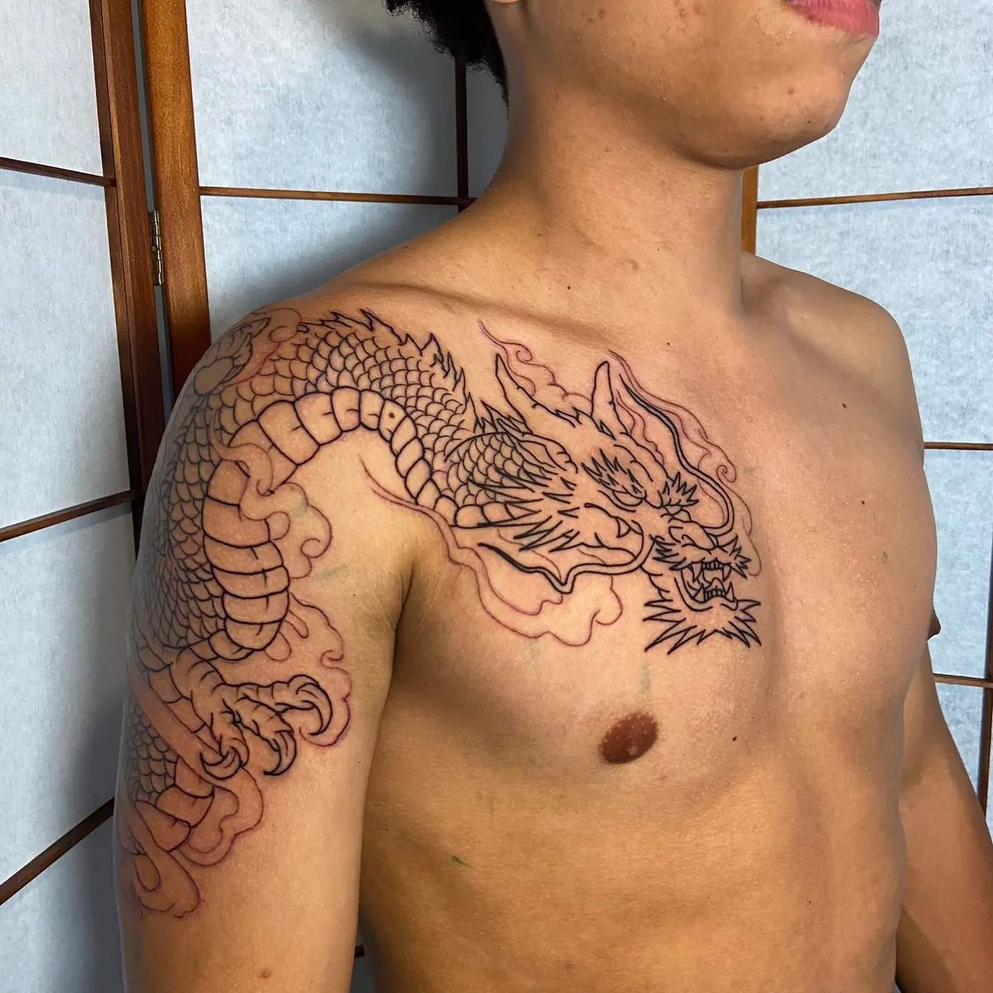 Dragão em linha fina no peito e ombro