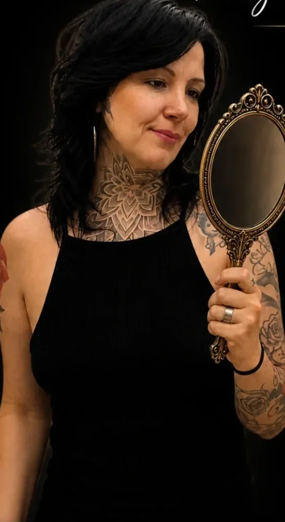 Andréia Oliveira de preto, segurando um espelho de mão dourado