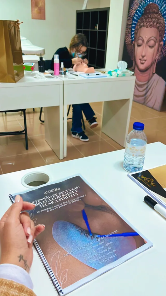 Apostila de formação aberta sobre a mesa durante uma aula prática