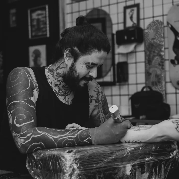 Fernando Fernandes tatuando um antebraço no estúdio