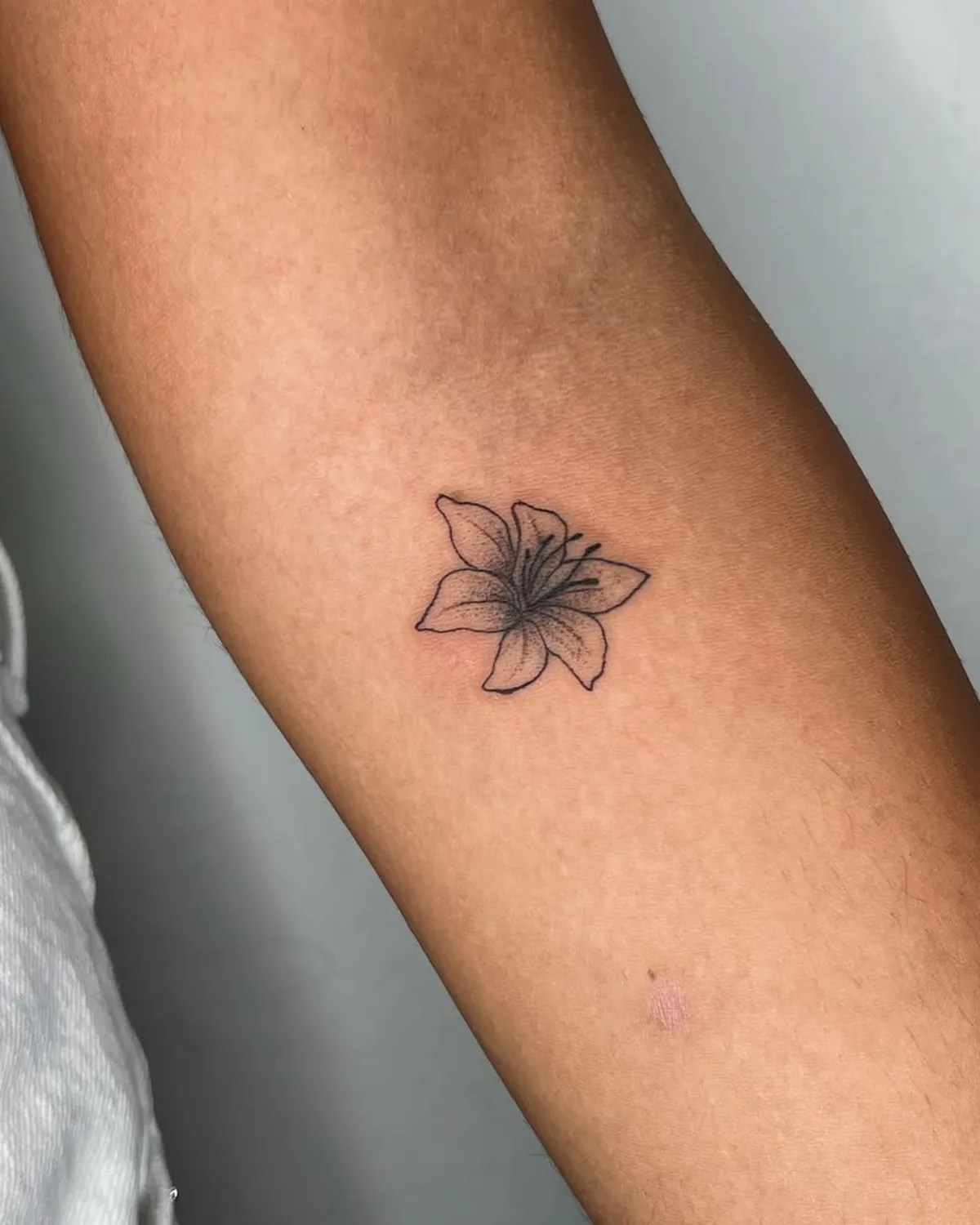 Flor fineline no braço