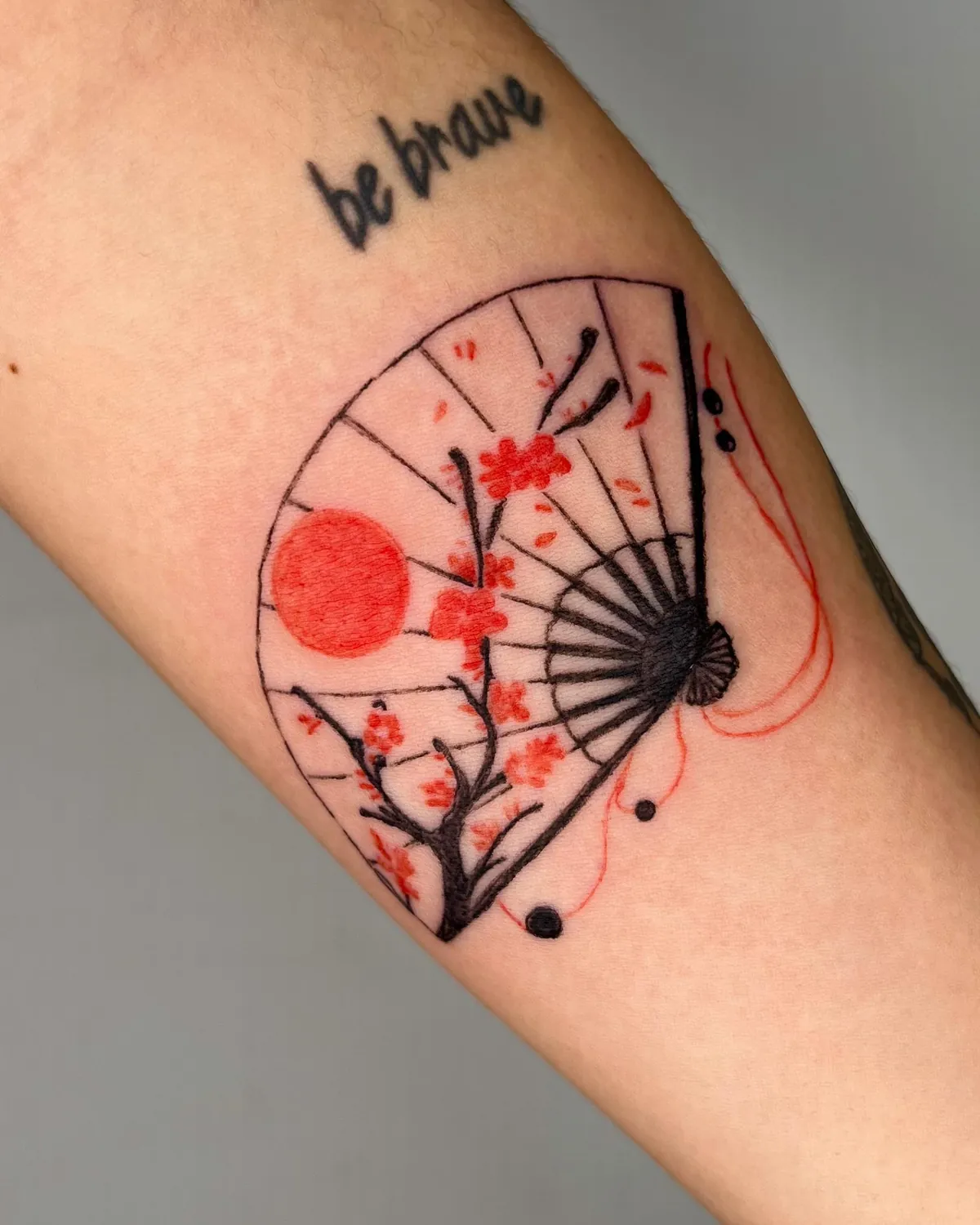 Leque com flores vermelhas e frase be brave